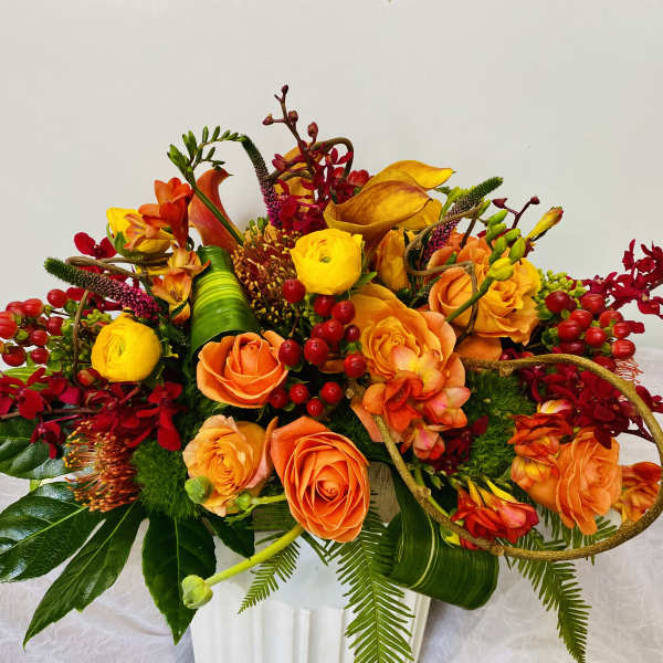 Orange and yellow floral arrangement in a white vase