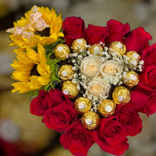 Bouquet of red and cream roses with yellow flowers and gold-wrapped chocolates