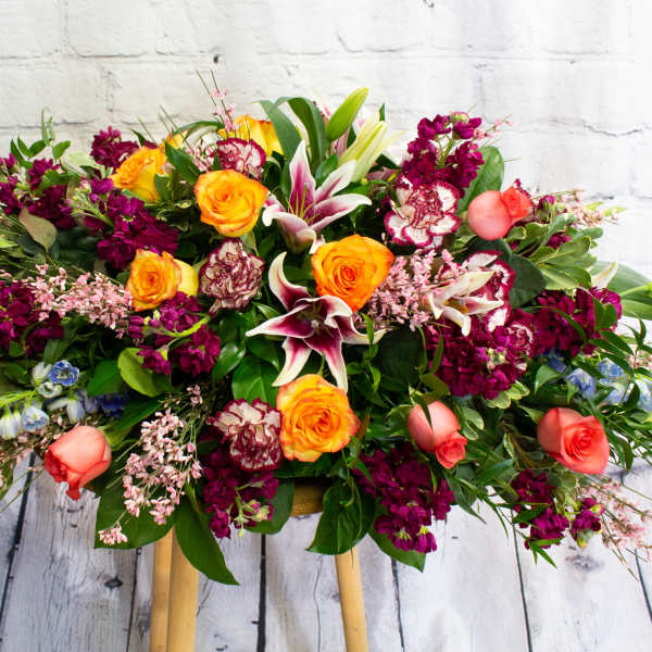 Large mixed bouquet with orange roses, lilies, and magenta flowers