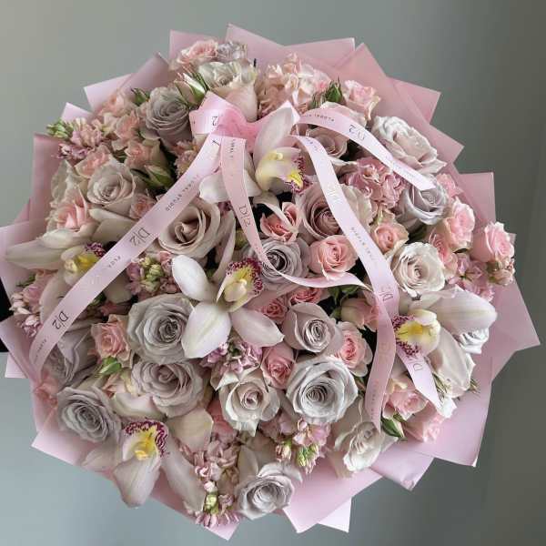 Large bouquet of pink and blush roses with orchids wrapped in pink paper