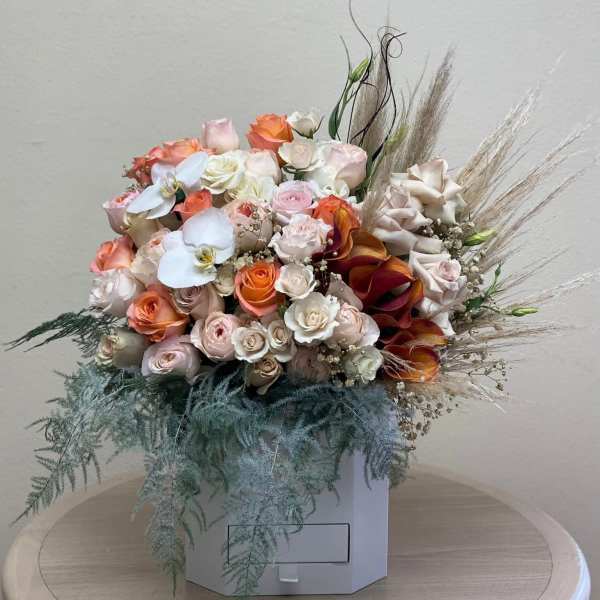 Mixed bouquet of roses, orchids, and calla lilies in a white box