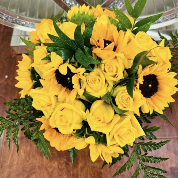 Yellow roses and sunflowers arranged in a bouquet