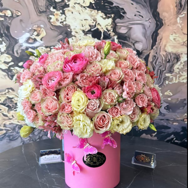 Large pink and cream rose arrangement in a pink cylindrical box