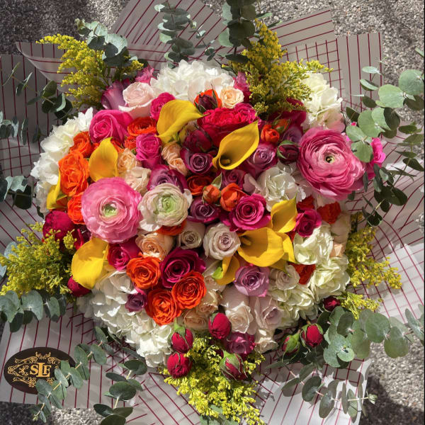 Large bouquet of pink, orange, yellow, and white flowers with eucalyptus