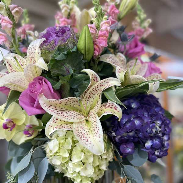Bouquet of lilies, roses, hydrangea, and snapdragons in pink, purple, and white