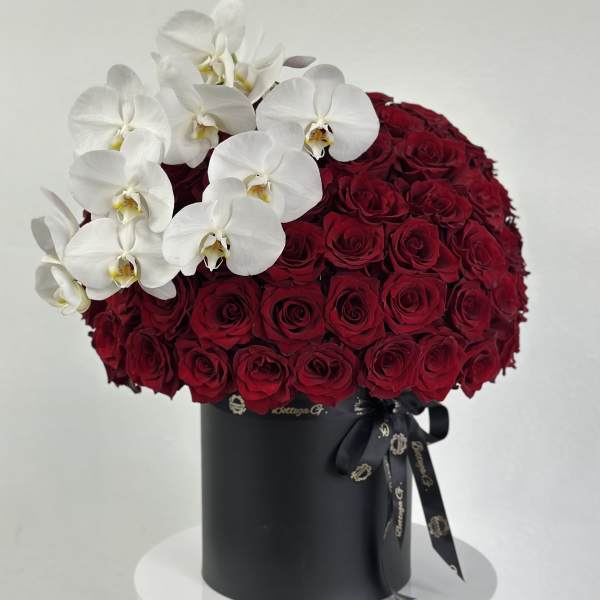 Red roses in a black hatbox with white orchids