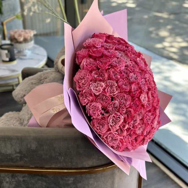 Large bouquet of pink roses wrapped in pastel paper