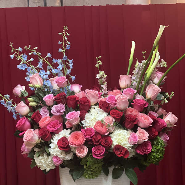 Large arrangement of pink and red roses in a white vase