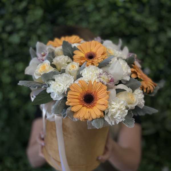 Bouquet of orange gerbera daisies and white roses in a tan box