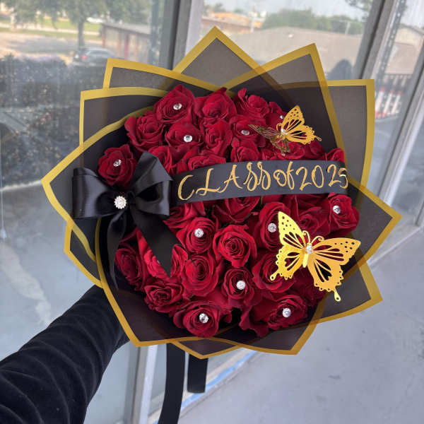 Bouquet of red roses with black and gold wrapping and butterfly accents