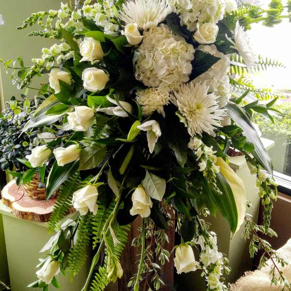 Large white floral standing spray with roses, hydrangeas, and chrysanthemums