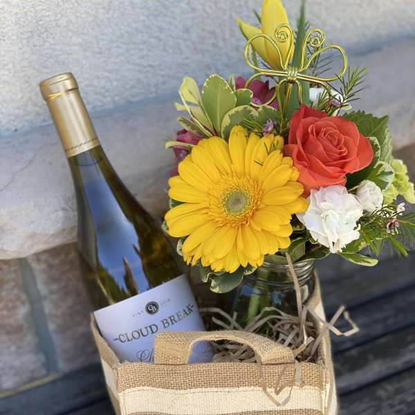 Flower gift bag with a wine bottle and a small mixed bouquet