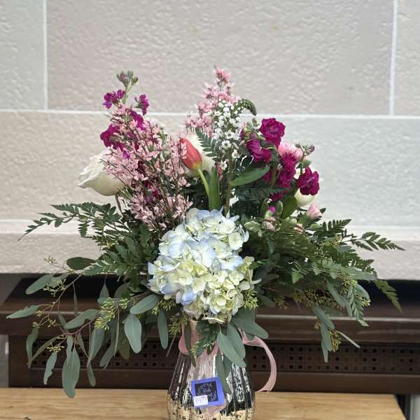 Mixed bouquet in a metallic vase with pink, white, and blue blooms