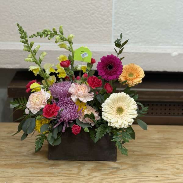 Mixed flower arrangement in a dark rectangular container