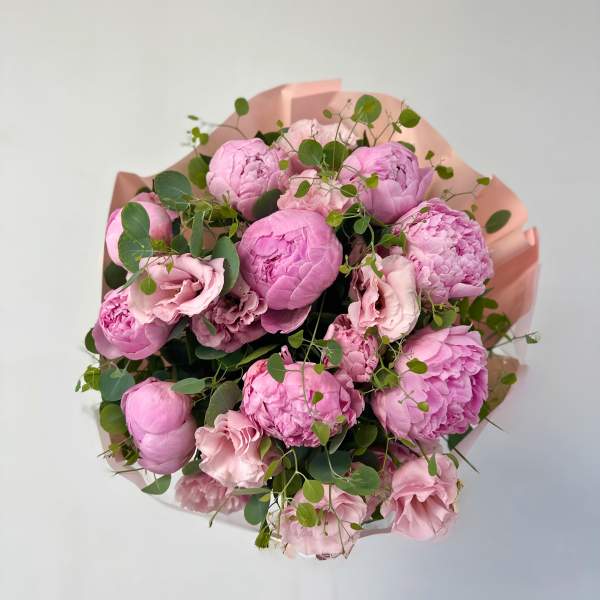 Pink peonies and lisianthus bouquet with eucalyptus in blush wrap