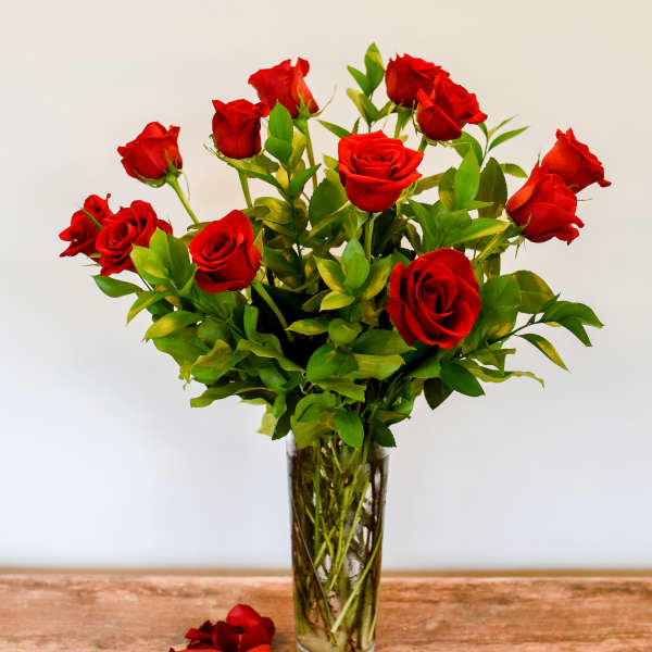 Red roses arranged in a clear glass vase