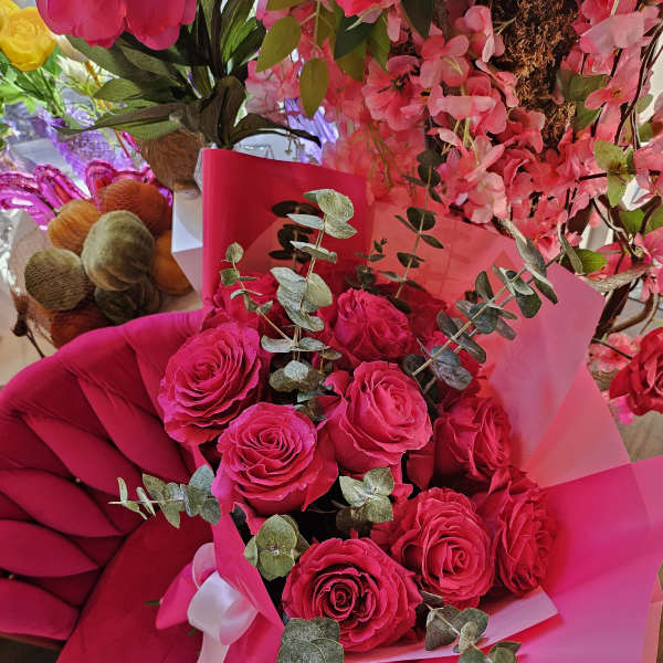 Bouquet of hot pink roses with eucalyptus in pink wrapping