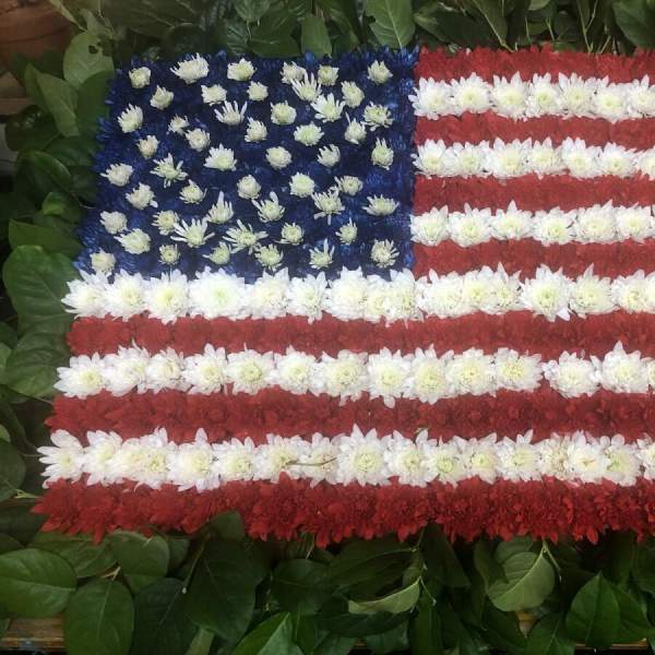 Floral arrangement shaped like the American flag with red, white, and blue flowers