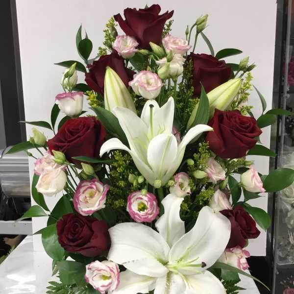 Arrangement of red roses, white lilies, and pink lisianthus