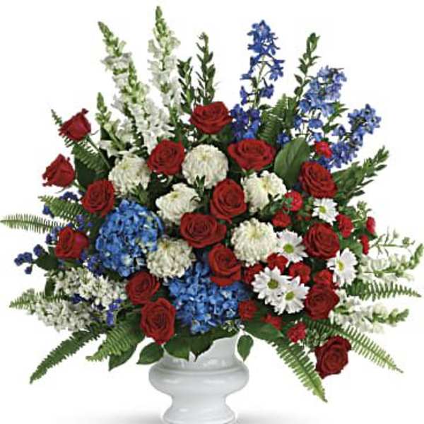 Red roses, blue and white flowers in a white vase