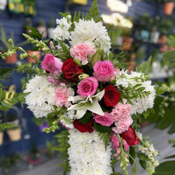 Standing floral spray with red and pink roses, white blooms, and lilies
