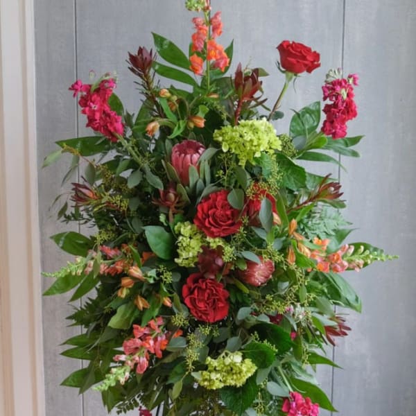 Tall standing floral spray with red roses and pink blooms