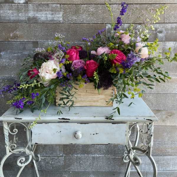 Mixed bouquet in a wooden box with pink, purple, and white flowers