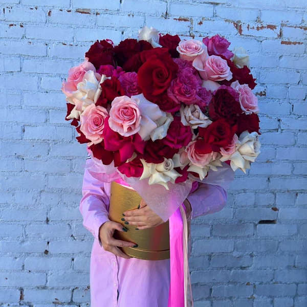 Large bouquet of red, pink, and white roses in a gold box