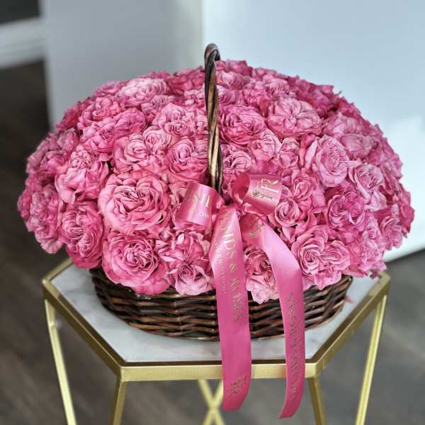Basket of pink roses with a pink ribbon bow