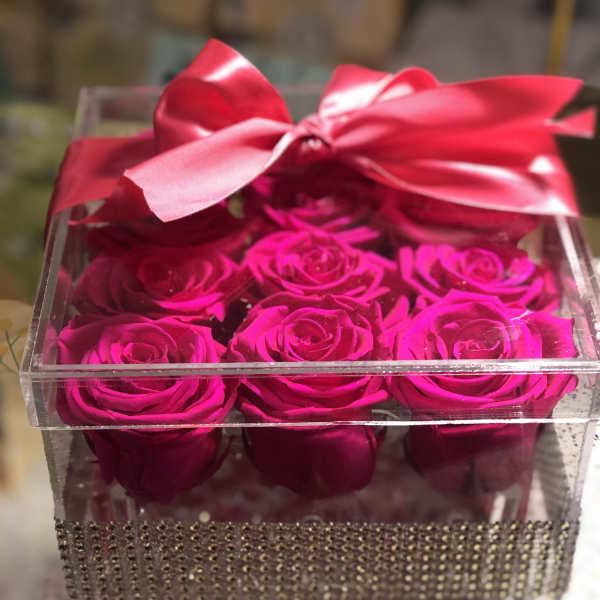 Clear gift box with hot pink roses and a satin bow