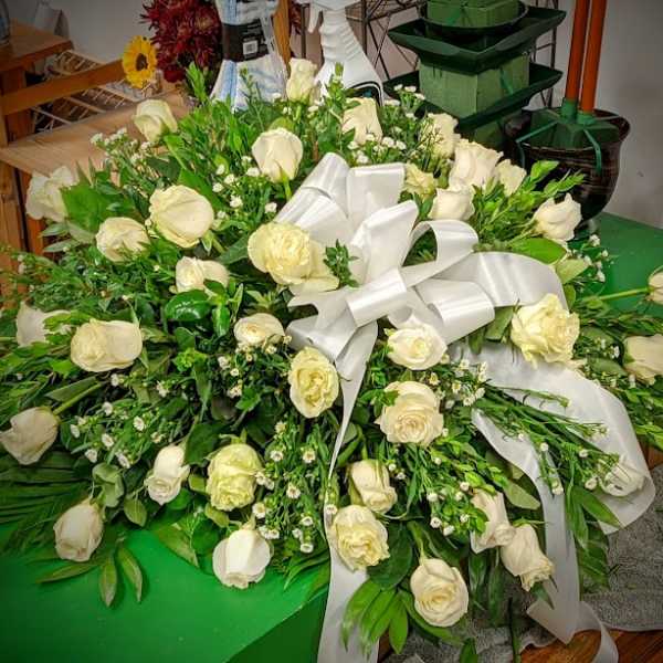 Large white rose arrangement with a satin ribbon bow