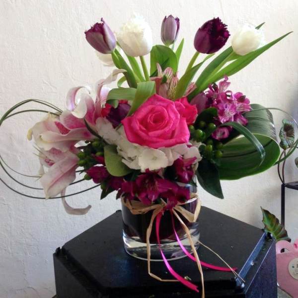 Pink rose and mixed flower arrangement in a glass vase