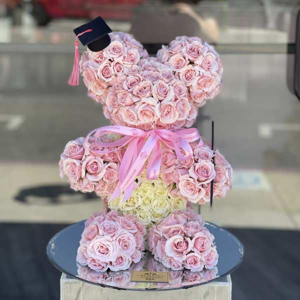 Pink rose teddy bear with a graduation cap and ribbon bow
