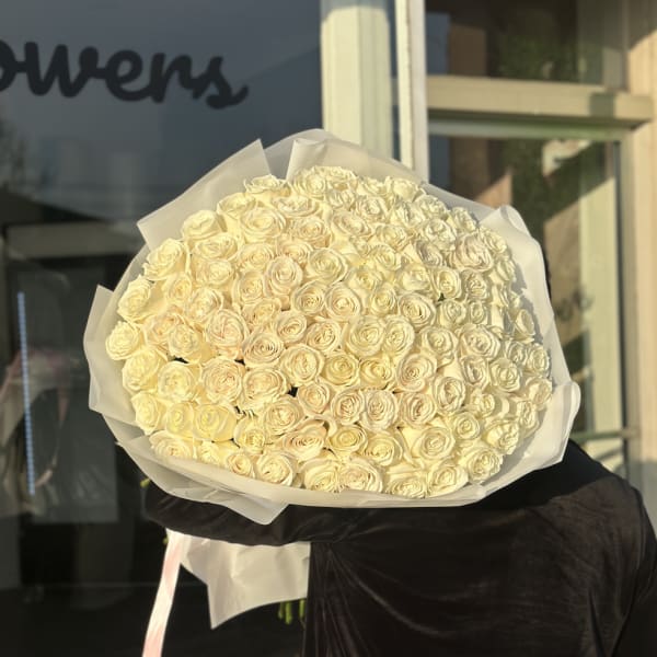 Large bouquet of cream roses wrapped in white paper