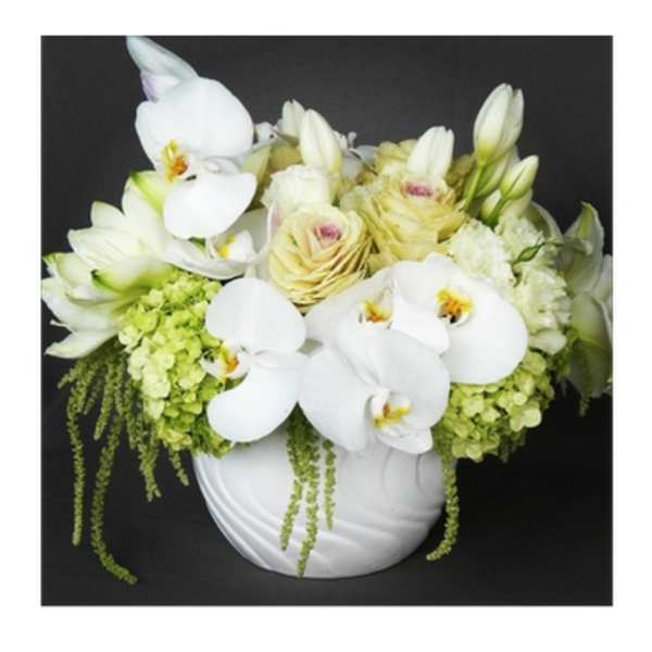 White orchids and pale yellow roses in a white vase