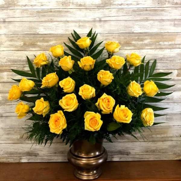 Yellow roses arranged in a bronze vase