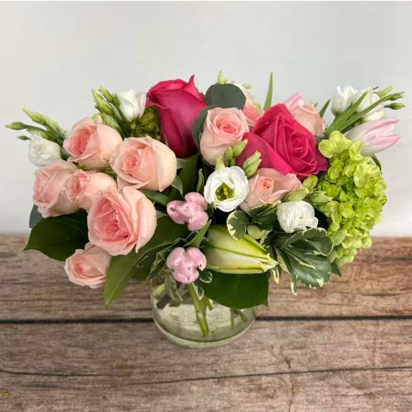 Pink and white rose bouquet in a clear glass vase