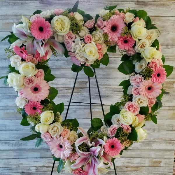 Heart-shaped floral wreath with pink and white roses and gerbera daisies