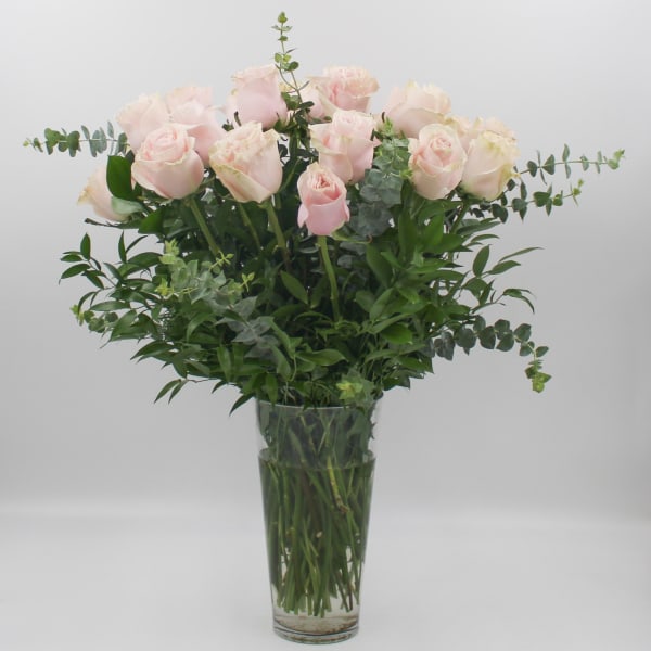Bouquet of pale pink roses in a clear glass vase
