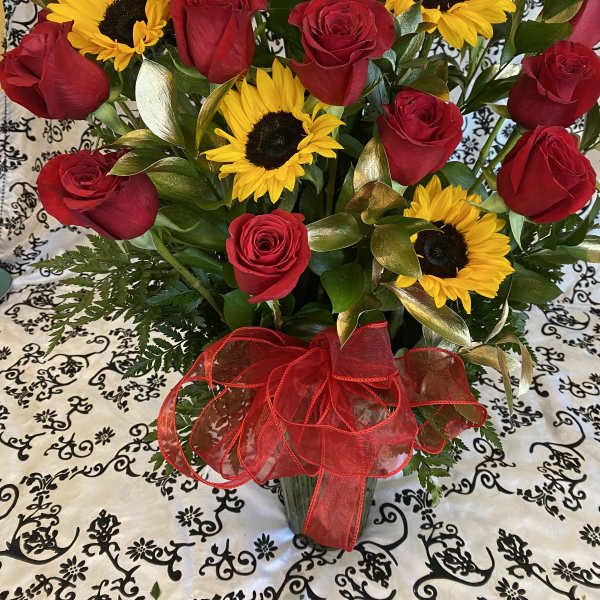 Bouquet of red roses and yellow sunflowers with a red ribbon