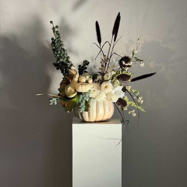 Pumpkin arrangement with white flowers and dark ornamental grasses