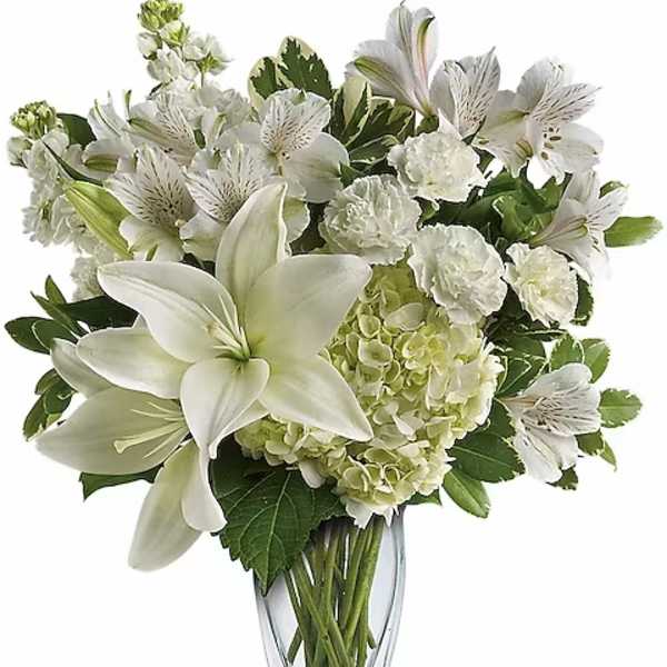 White lilies and alstroemeria in a clear glass vase