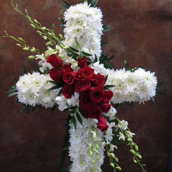 Cross-shaped floral arrangement with white blooms and red roses