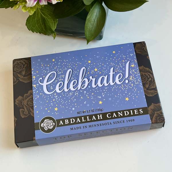 Bouquet with a pink rose and purple-white daisies beside a candy box