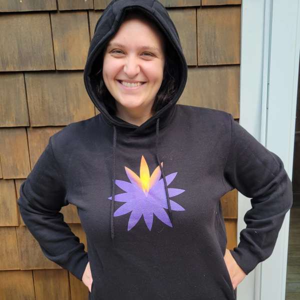 Person wearing a black hoodie with a purple and yellow flower graphic
