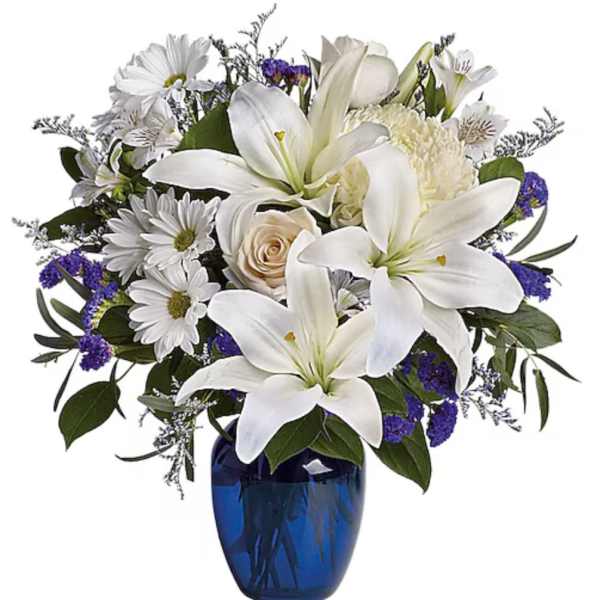 White lilies and daisies in a blue glass vase