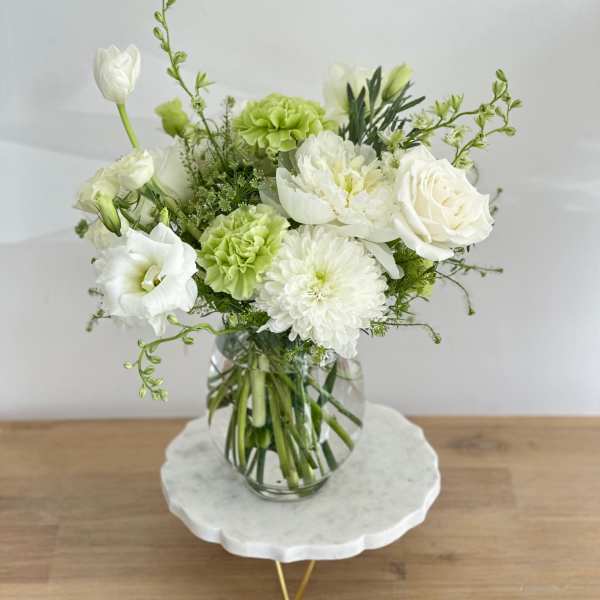 White and green floral arrangement in a clear glass vase