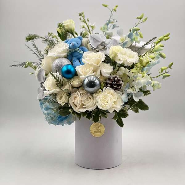 White rose bouquet with blue ornaments in a round box