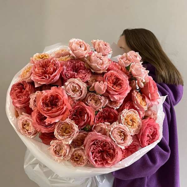 Large bouquet of pink and coral roses wrapped in white paper