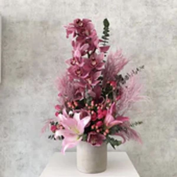 Tall pink floral arrangement in a white vase